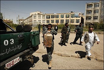 A policeman carries a gas cylinder that was attached to a bomb after it was discovered on a street in Herat, Afghanistan, Wednesday, Aug. 19, 2009. Afghans will head to the polls on Aug. 20 to elect the new president. (AP Photo/Saurabh Das)