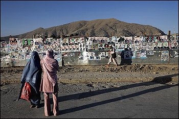 Afghan people pass by a wall of election campaign posters in downtown Kabul, Afghanistan, Wednesday, Aug. 19, 2009, on the eve of the presidential elections. (AP Photo/David Guttenfelder)