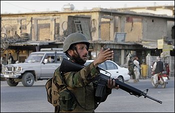 An Afghan soldier gestures to drivers at a check post in city of Kandahar province south of Kabul, Afghanistan on Wednesday, Aug. 19, 2009. Afghans are on the eve of going to the polls to elect a new president for the second time in the country's history. (AP Photo/Musadeq Sadeq)