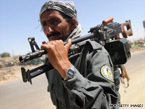 An Afghan police officer walks near a bank in Kabul where an armed robbery ended in a gunbattle.