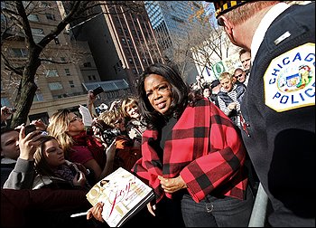 ANOTHER SIGNATURE MOMENT: Winfrey signs copies of her magazine in a Chicago park earlier this month.