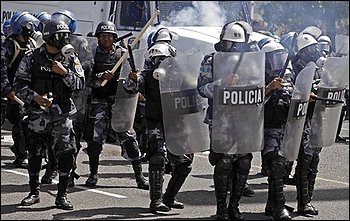 Riot police throw tear gas to disperse a march of ousted Honduras' President Manuel Zelaya's supporters demanding his return to power in Tegucigalpa, Thursday, Oct. 29, 2009. Honduras' opposing political factions resumed talks Thursday and expressed hope that a deal could be reached soon to end the power crisis that has paralyzed the country since a coup four months ago. (AP Photo/Arnulfo Franco)